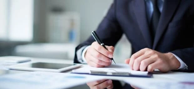 A white-collar worker sitting at a desk with office supplies, job-related equipment, and learning materials.