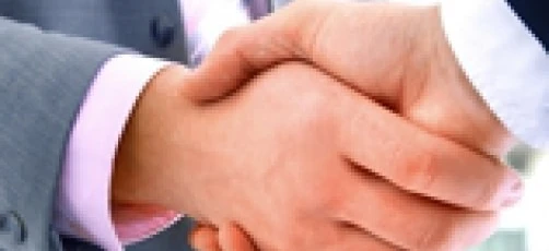 Two white-collar workers greeting each other with a handshake in a gesture of collaboration and mutual respect. Businessperson networking and building relationships.