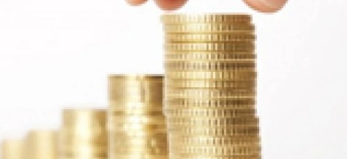 Close-up of a hand holding currency coins and banknotes. Concept of money handling, saving, and charity.