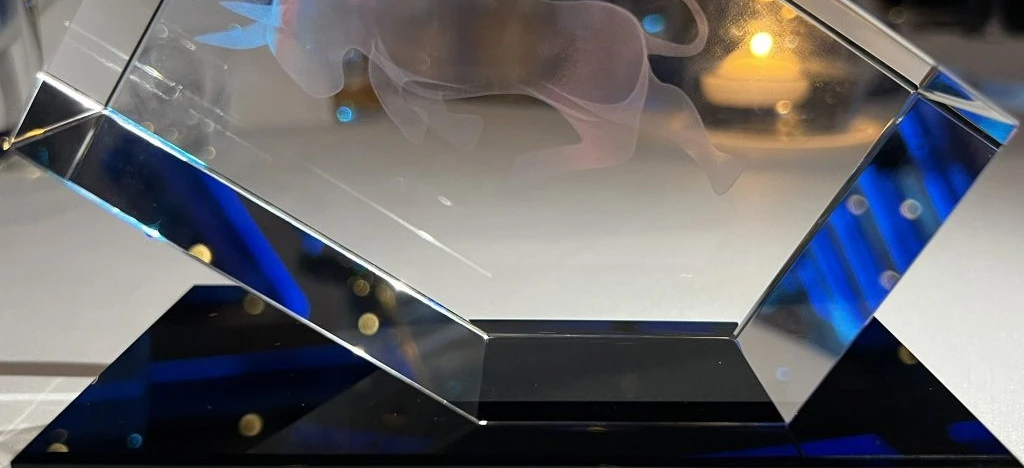 Silver crystal trophy in a glass display case awarded to UNIMOT for best investor relations. Winner of the 2022 Capital Market Hero Award by the Association of Individual Investors.