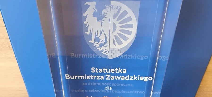Award for Adam Sikorski for his social activity, care for people, and safety. Gmina Zawadzkie banner with VIT graphics.