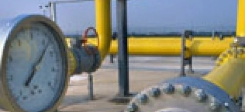 A close-up of metal pipes and cylinders at an industrial pumping station. This image depicts the engineering and construction of a plumbing system.
