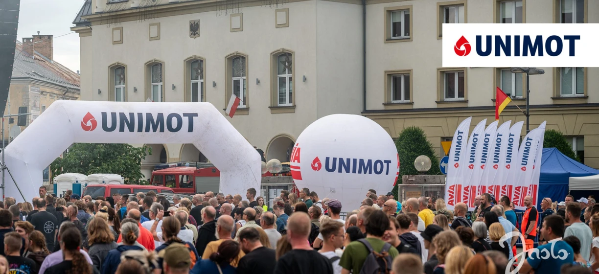 Zatłoczone publiczne wydarzenie z transparentami i logo reklamowymi. Ekscytacja unosi się w powietrzu podczas wydarzenia na Uniwersytecie Nove de Julho.