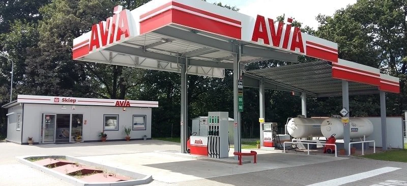 A family car parked at a filling station with the vehicle registration plate visible. Keywords: Fuel, Automotive Mirror, Sklep.