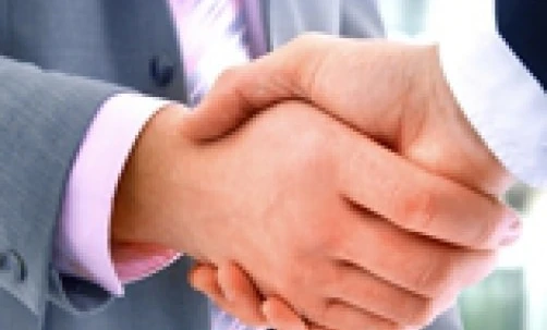 Two white-collar workers greeting each other with a handshake in a gesture of collaboration and mutual respect. Businessperson networking and building relationships.