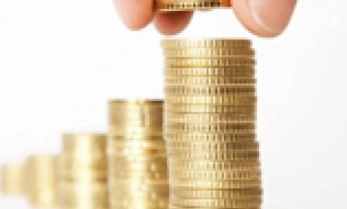 Close-up of a hand holding currency coins and banknotes. Concept of money handling, saving, and charity.