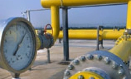 A close-up of metal pipes and cylinders at an industrial pumping station. This image depicts the engineering and construction of a plumbing system.
