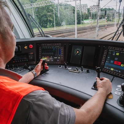 Pociąg pasażerski z lokomotywą, wagonem pasażerskim i wycieraczką na torze. Środek transportu publicznego. SEO: Pociąg, Tabor kolejowy, Transport kolejowy.